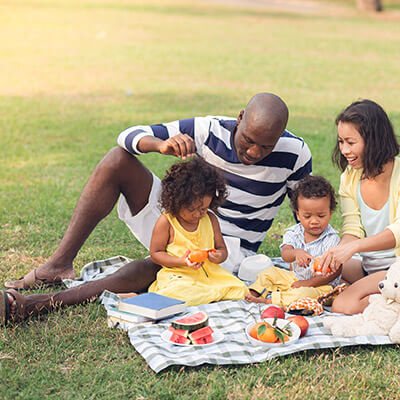 family picnic with parents peeling tangerines for kids