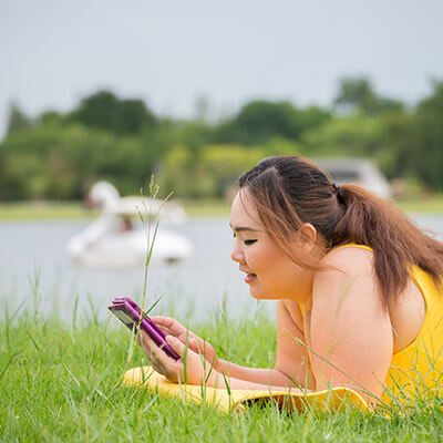 woman on grass with cellphone