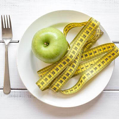 a plate with an apple and a measure band