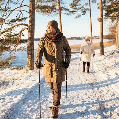 A man and a woman walking in the snow