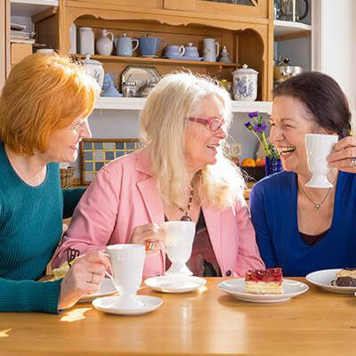 Three women discussing and having tea